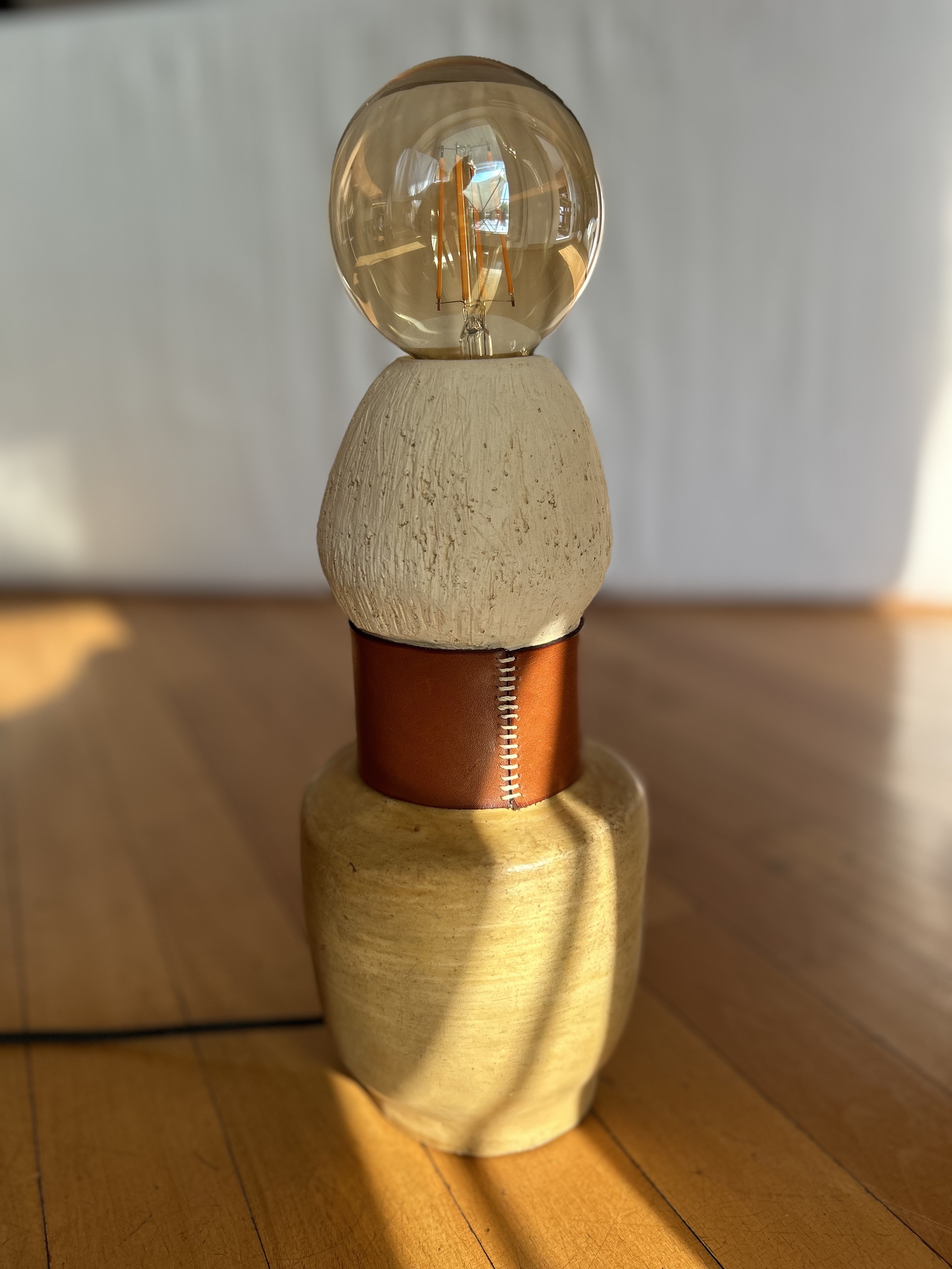 Ceramic lamp with leather band and warm bulb